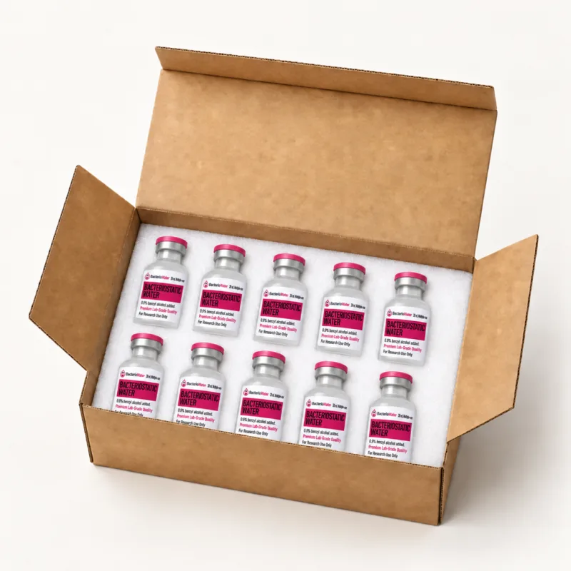 Sealed 30 mL bacteriostatic water vials with pink flip-off caps nested in white protective foam inside a plain cardboard shipping box
